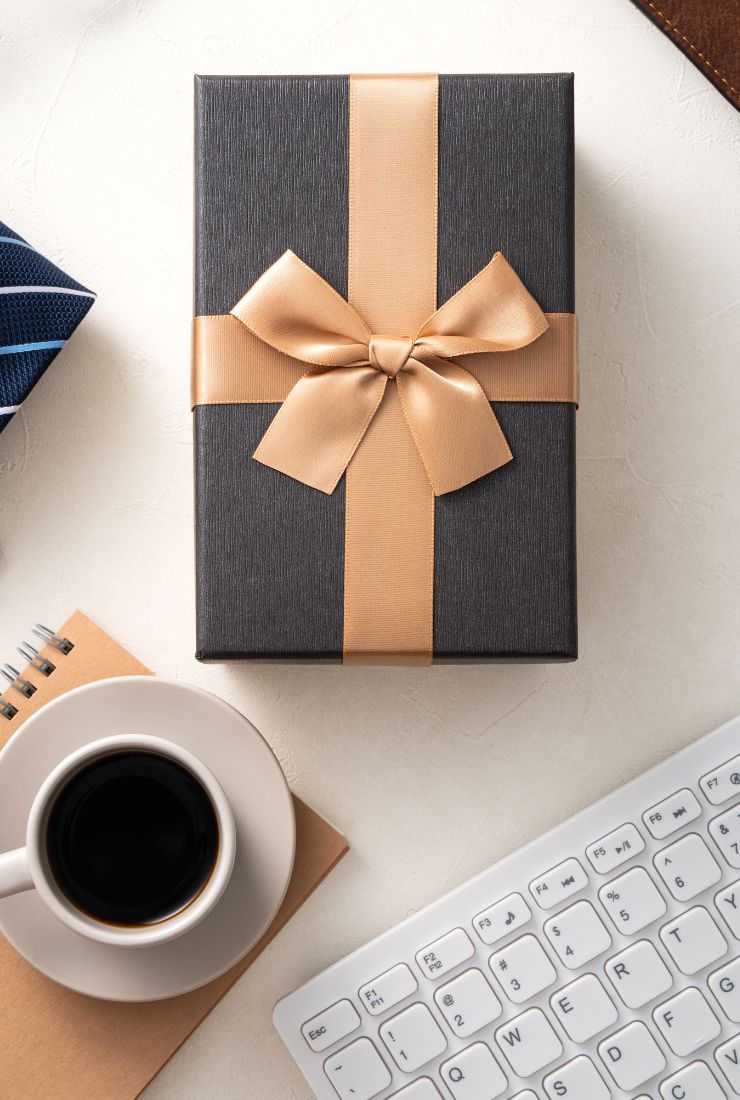 Gift on desk beside laptop representing KULA's corporate gifting options for clients, employees and suppliers