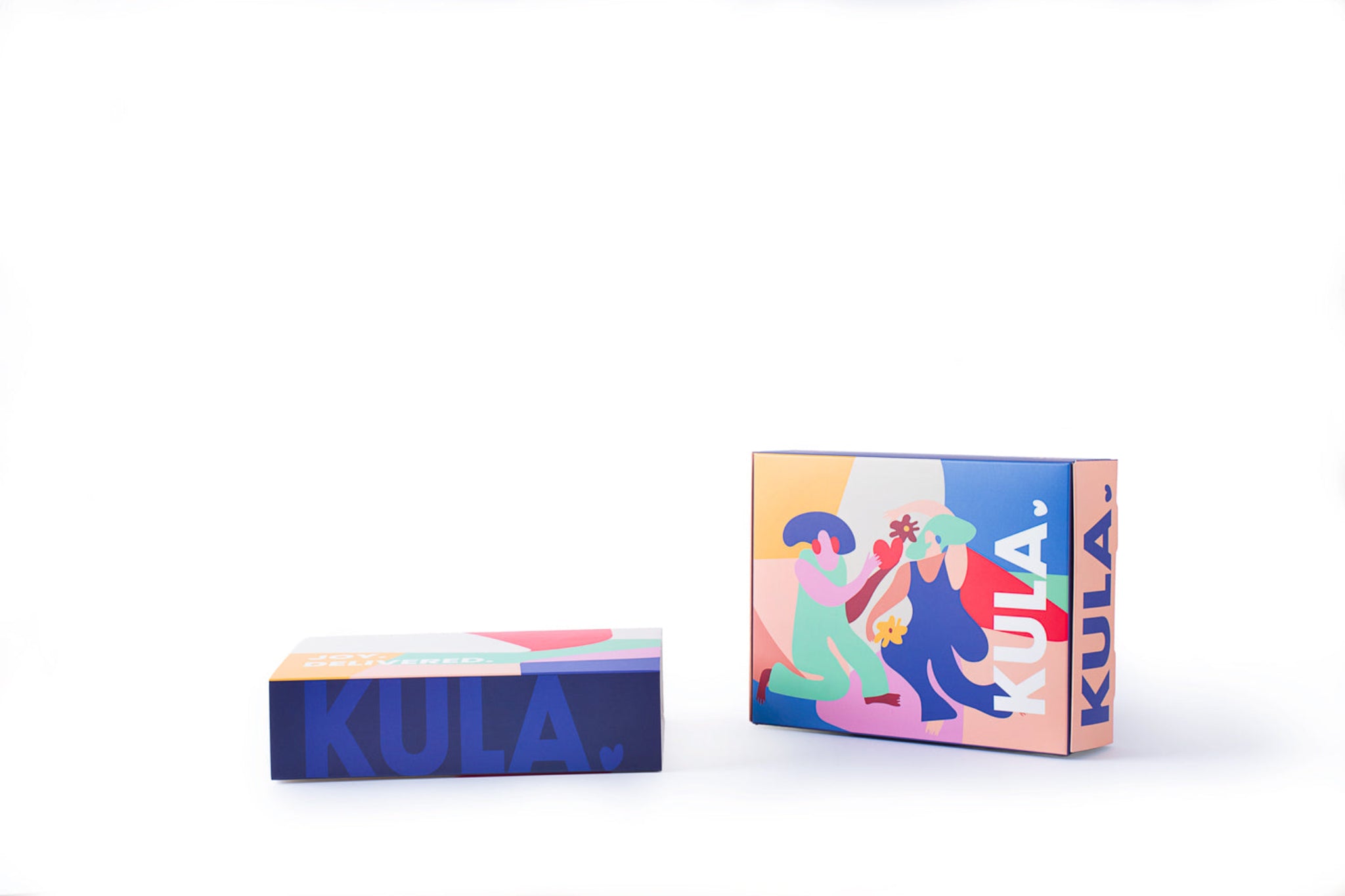 Side-by-side view of KULA gift boxes, featuring a vibrant sleeve design with colourful illustrations of people sharing kindness. Perfect for unique gifting experiences.