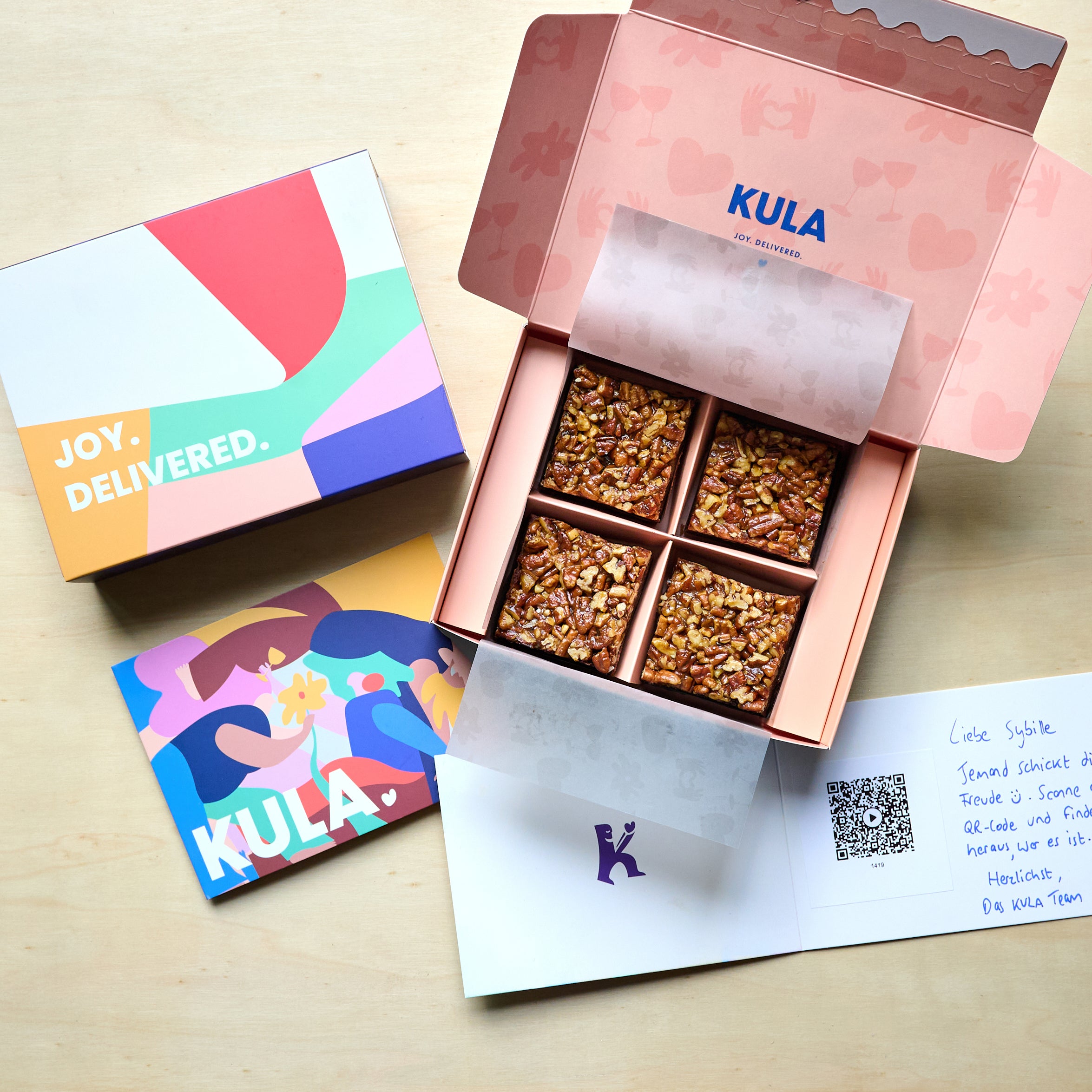 Open KULA gift box with 4 salted caramel brownies, an open handwritten card with scannable personal video message.