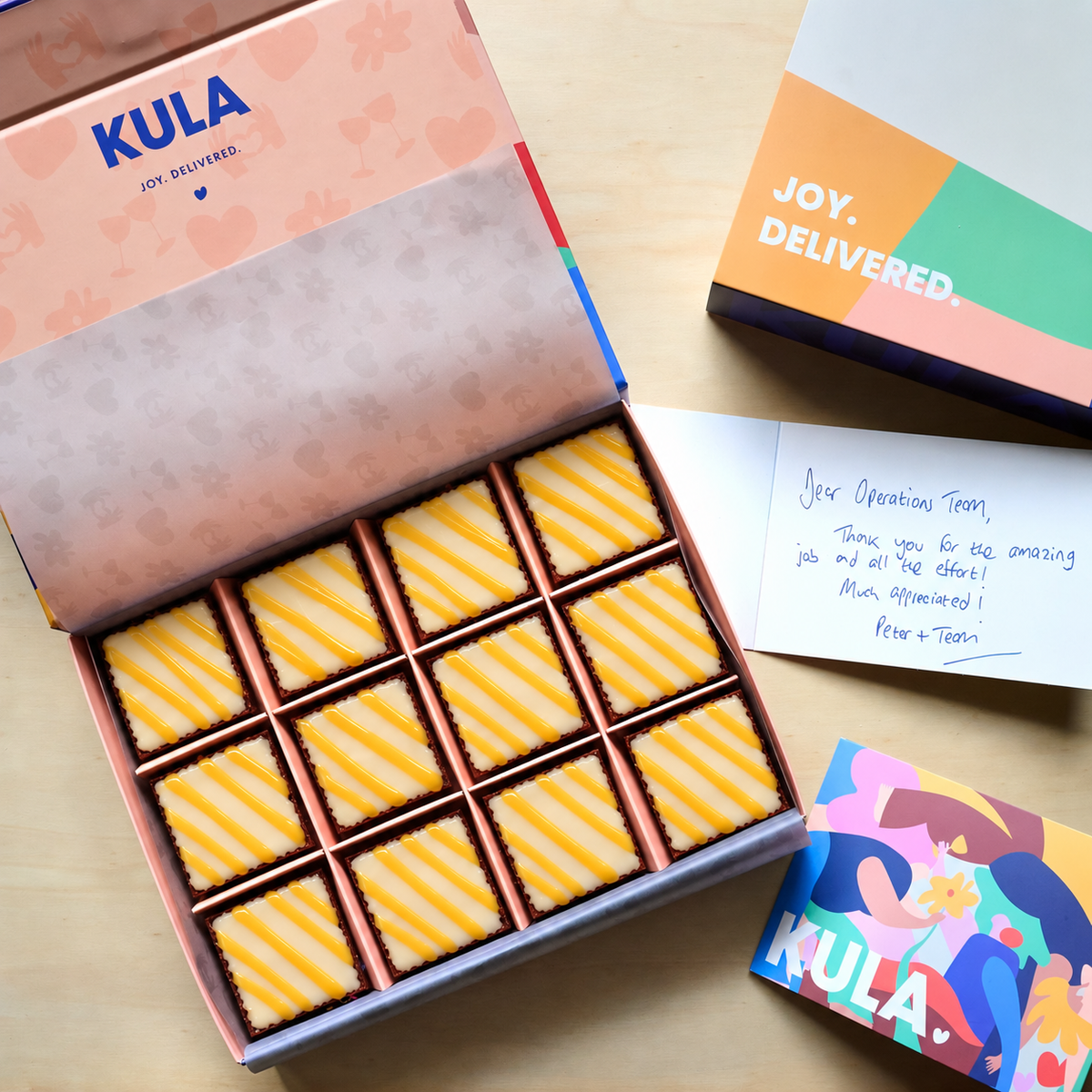 Zwölf Pumpkin Spice Brownies mit weisser Schokoladen-Kürbis-Ganache in der KULA Box